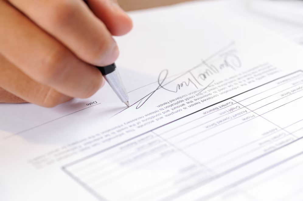 Closeup of a person signing a document