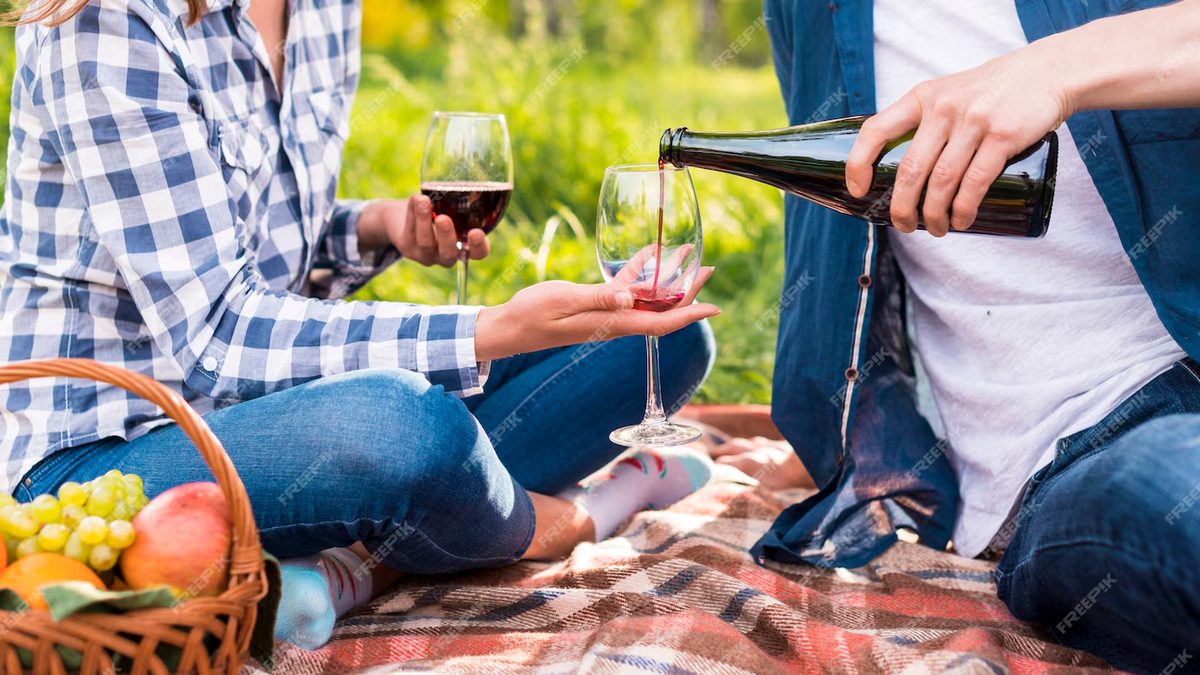 Person pouring wine into two glasses