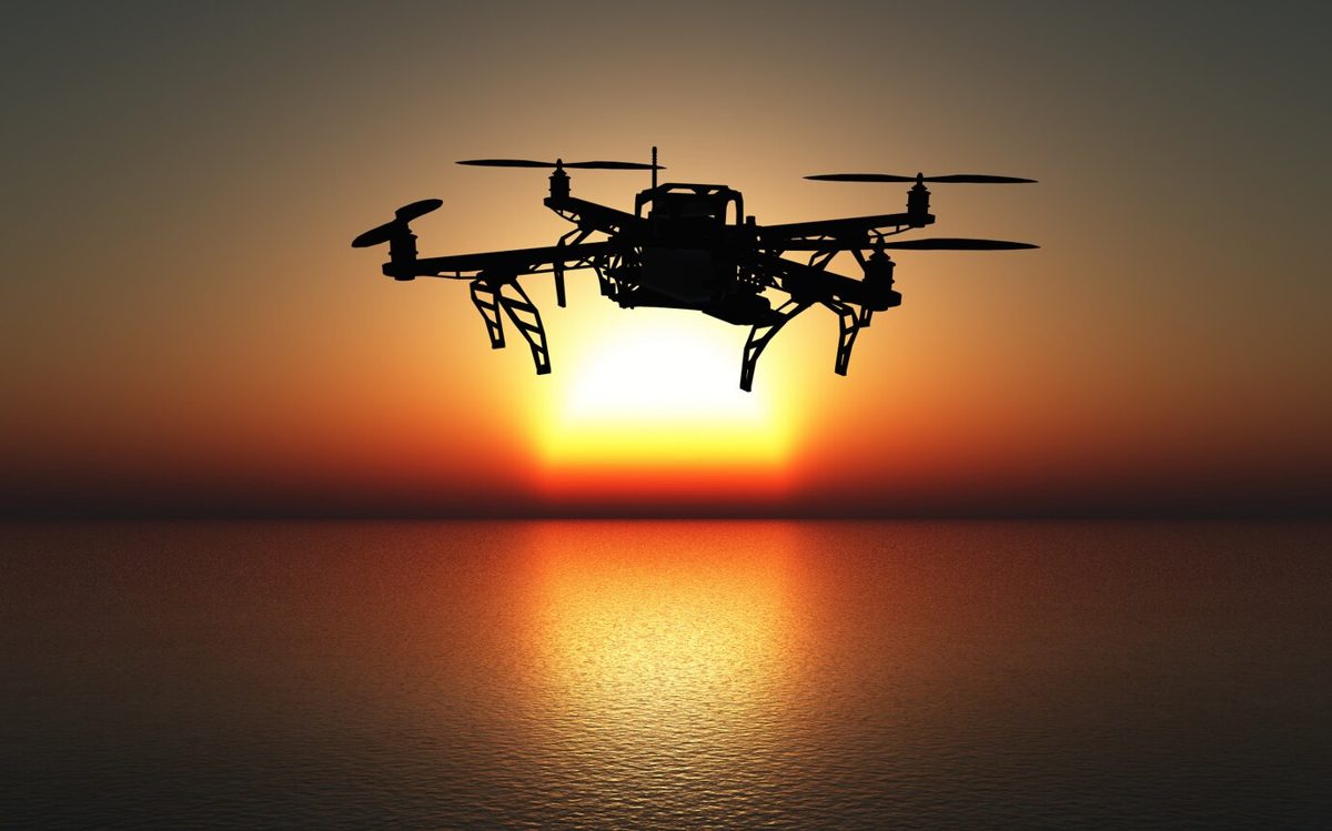 Drone flying above the sea at sunset