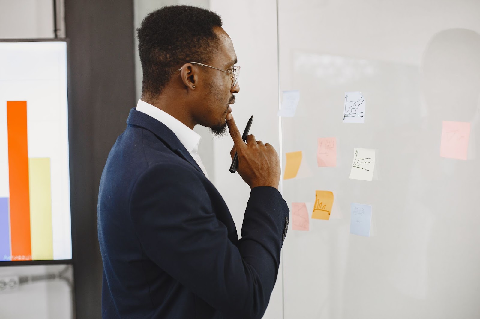Man in a black suit writing on glass