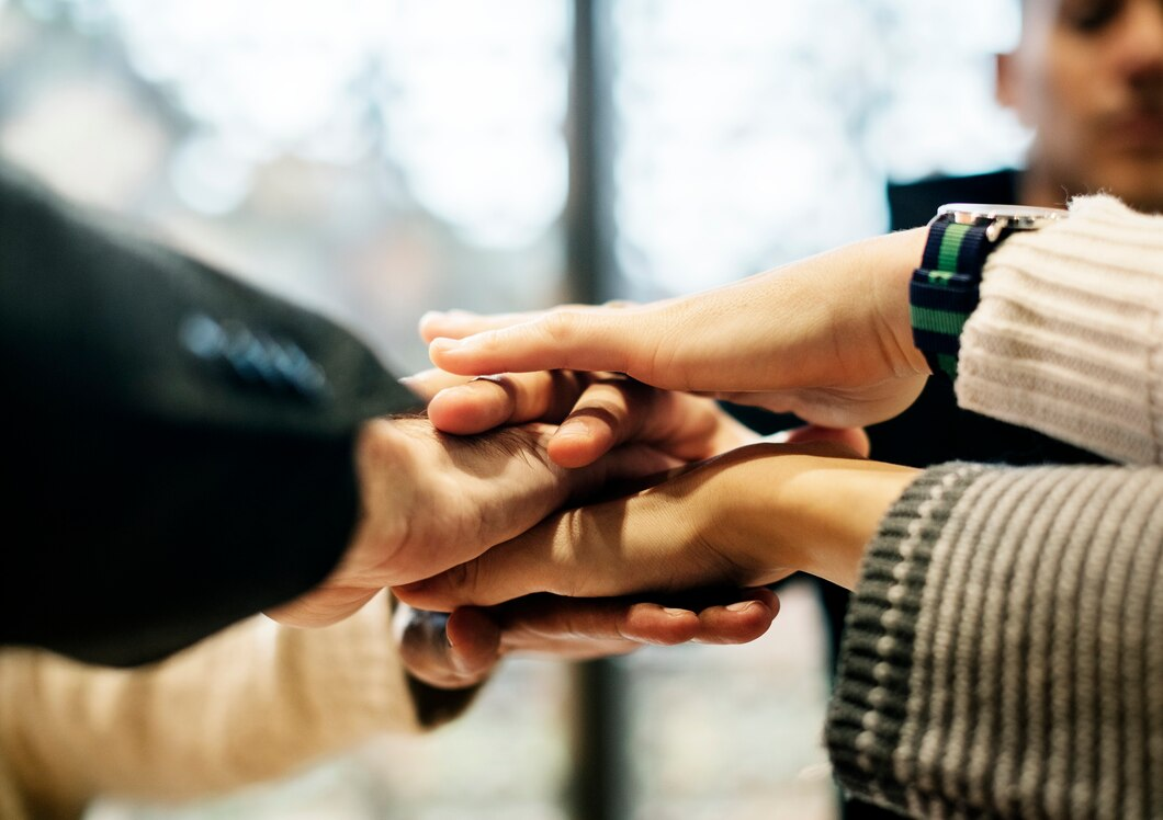 Diverse people stacking hands together at a community event