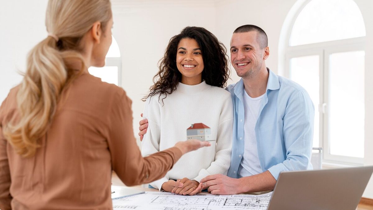 Smiling couple talking with a female realtor about a property purchase