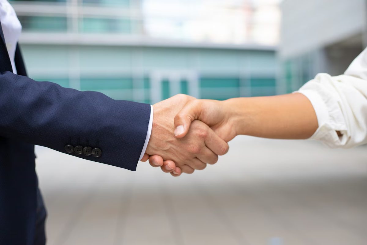 Close-up of a business handshake between two people in formal suits
