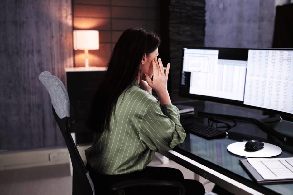 Frustrated broker looking at scattered spreadsheets